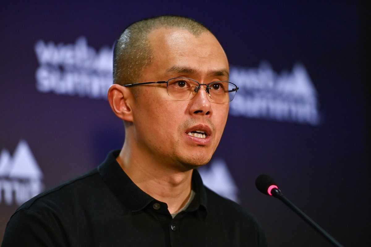 Binance founder Changpeng Zhao speaking at a microphone at Web Summit in 2022